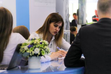 Kız tezgahın arkasında yazıyor.