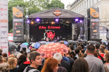 Şemsiye altında ziyaretçiler vardır.