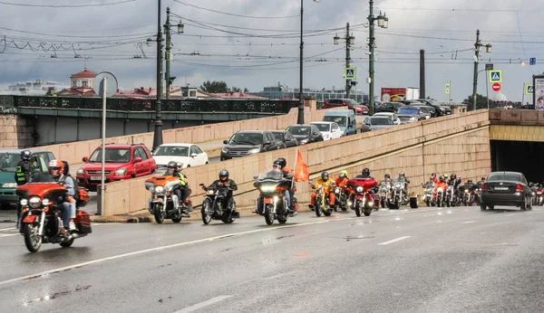 En kolumn av motorcyklister blad från under bron. — Stockfoto