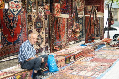 Yaşlı bir satıcı halı.