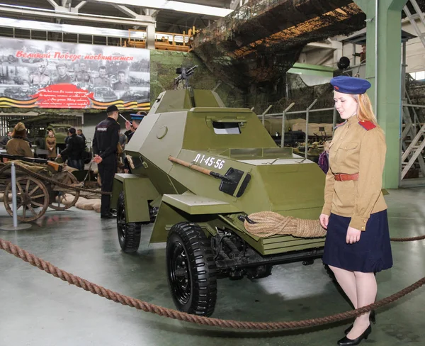Meisje in uniform met een pantserwagen. — Stockfoto