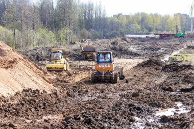 Alanda kirli toprak parçaları var. Volkhov Nehri üzerinde bir motor köprüsü inşa edilmeye başlandı.