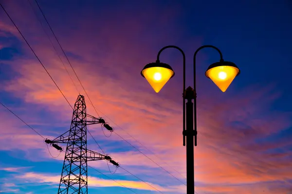 electricity pylon and streetlamp at sunset