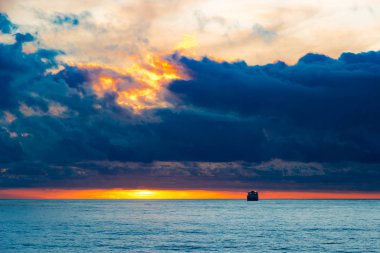 Ufukta gemiyle deniz batımı manzarası