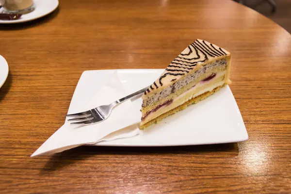 Stück Marzipankuchen mit Tablett und Gabel serviert in einer Kaffeebar — Stockfoto