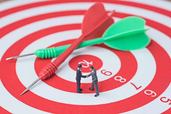 Businessman make agreement on red and green darts on center of d — Stock Photo, Image