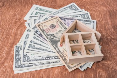 ahşap ev modeli üzerinde dolar para