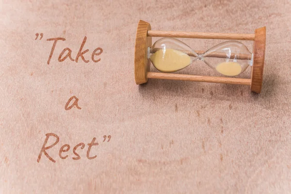 Vintage sandglass op houten tafel met tekst "nemen een Rest" — Stockfoto