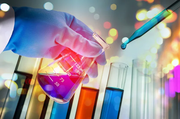 Dubbel exponering av vetenskapsman handen håller laboratorium provrör — Stockfoto