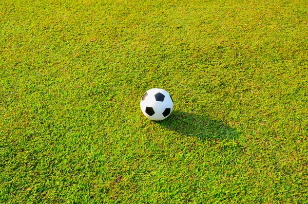 Football or soccer ball on green grass field — Stock Photo, Image