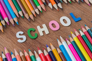 arka plan için çok renkli kalemler arasında ahşap metin okul