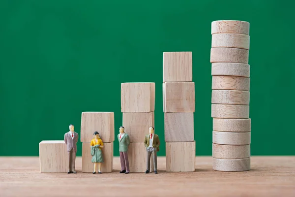 Stack of wood cube building blocks and miniature people — Stock Photo, Image
