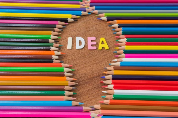 Drewna tekst "Pomysł" w multi kolor tła ołówki — Zdjęcie stockowe