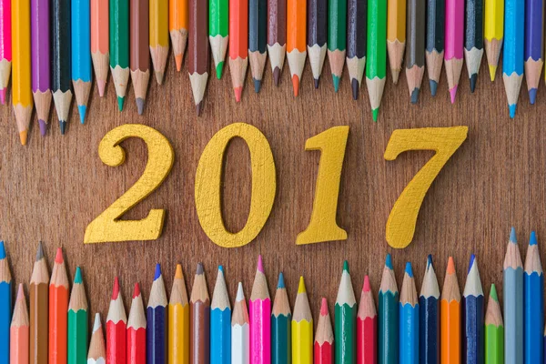 Номер тексту деревини 2017 між багатокольоровими олівцями для фону — стокове фото