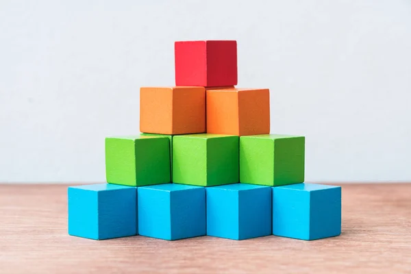 Pilha de blocos de construção de cubo de madeira colorido no fundo de madeira — Fotografia de Stock