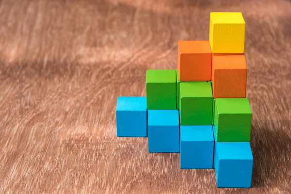 Stack of colorful wood cube building blocks on wood background — Stock Photo, Image