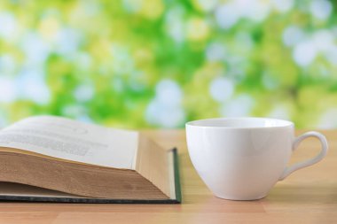 Beyaz kahve fincanı yeşil yaprakları arka plan ahşap tablo