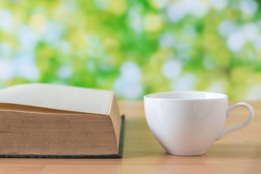 Beyaz kahve fincanı yeşil yaprakları arka plan ahşap tablo