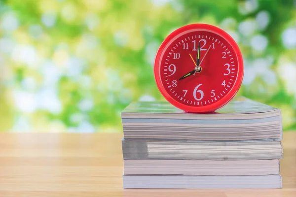 Horloge coeur rouge et livre ouvert sur table en bois — Photo