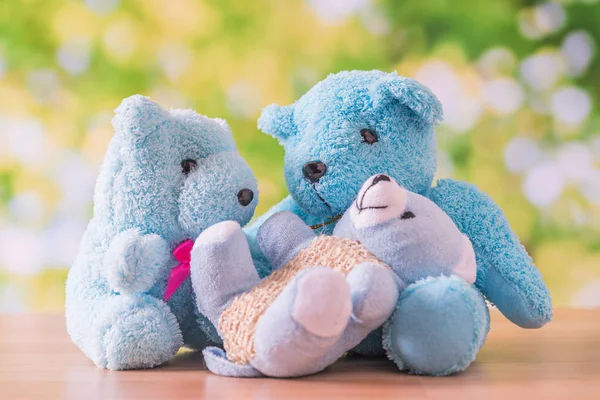 Blaubär Puppenfamilie sitzt auf Holztisch mit grünen natürlichen — Stockfoto