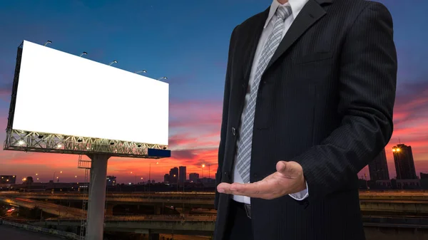 Üzletember és üres billboard a félhomályban ég naplemente készen — Stock Fotó