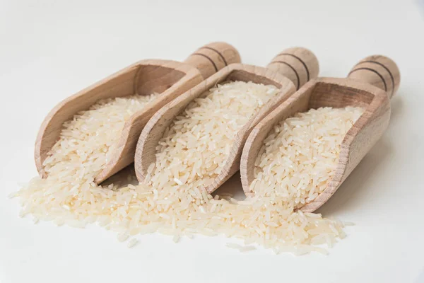 Uncooked rice in wooden scoop — Stock Photo, Image