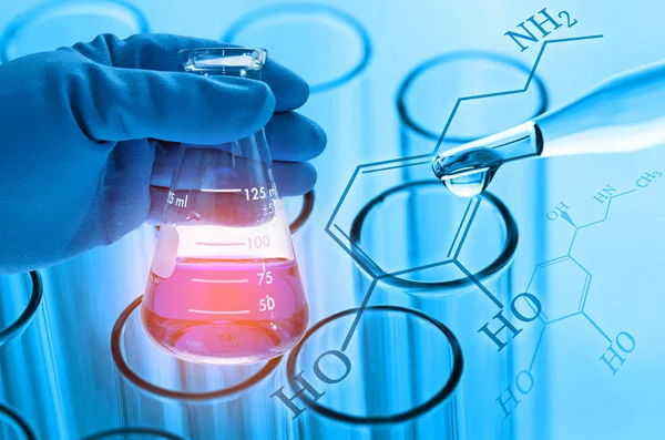 Cientista mão segurando frasco de laboratório com banheira de teste de laboratório — Fotografia de Stock