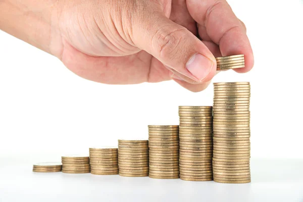 Man hand zetten geld aan stijgende munt stapels op witte achtergrond — Stockfoto