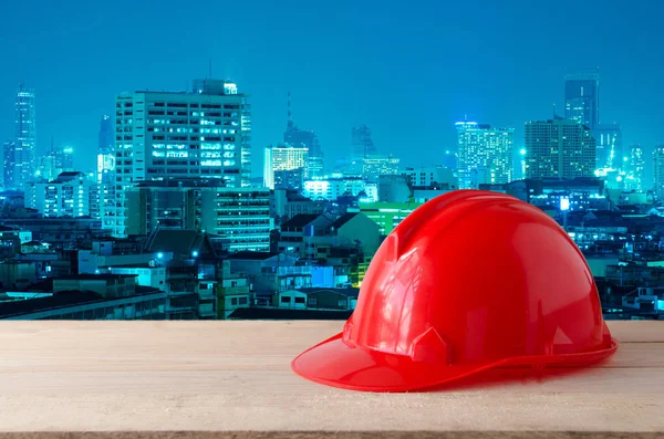 Rode veiligheidshelm met moderne stad nacht achtergrond bouwen — Stockfoto