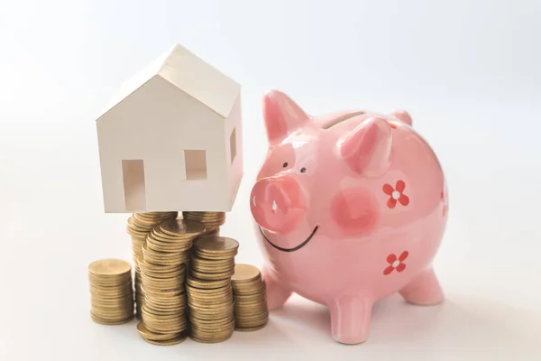 Huis model op munten stack en piggy bank — Stockfoto