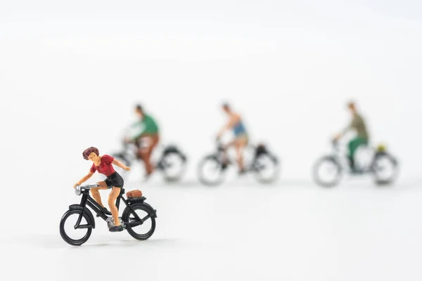 Miniature people cycling on white background — Stock Photo, Image