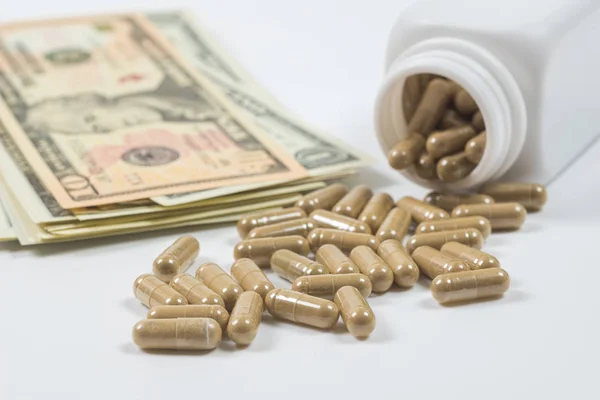 Pills spilling from Bottle with dollar money — Stock Photo, Image