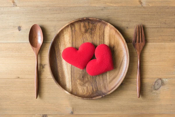 Dois corações vermelhos em prato de madeira — Fotografia de Stock