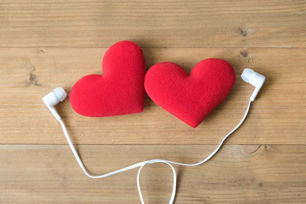 Para czerwone serce z słuchawek na podłoże drewniane — Zdjęcie stockowe