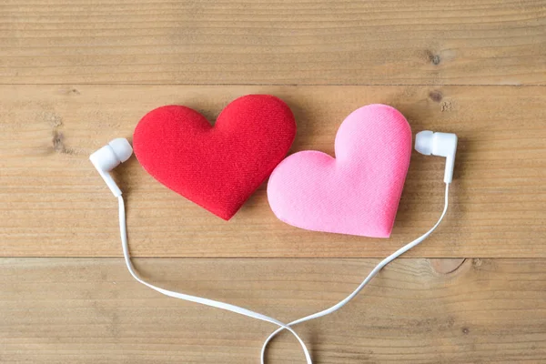 Pareja corazón rojo con auriculares sobre fondo de madera — Foto de Stock