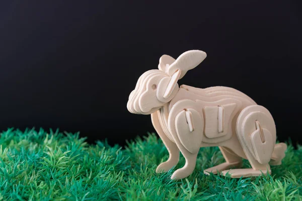 Houten konijn model op kunstmatige groene veld en zwarte CHTERGRO — Stockfoto
