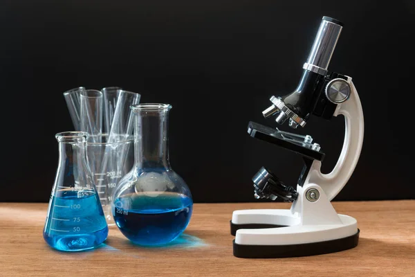 Tubos de ensayo de laboratorio de ciencia y microscopio blanco en lengüeta de madera — Foto de Stock