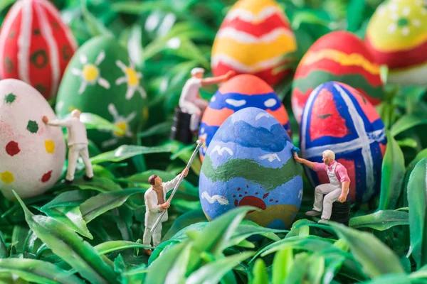 Gente en miniatura pintando huevos de Pascua —  Fotos de Stock
