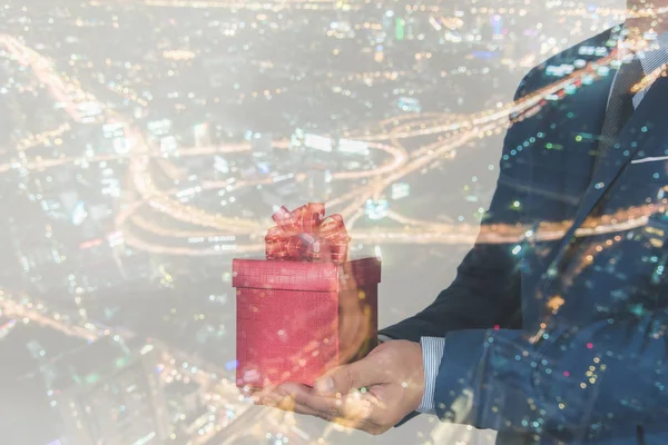 Zakenman geven gift aan partner met de nacht moderne stad backg — Stockfoto