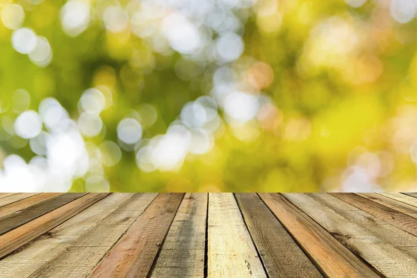 Дерев'яна полиця на розмитому зеленому парку на фоні заходу сонця — стокове фото