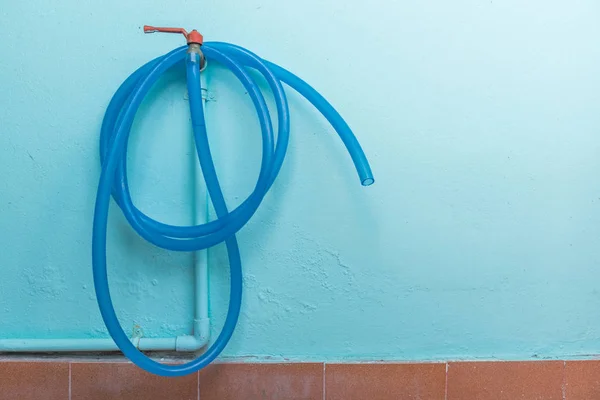 Rubinetto con tubo dell'acqua in gomma appeso al muro — Foto Stock