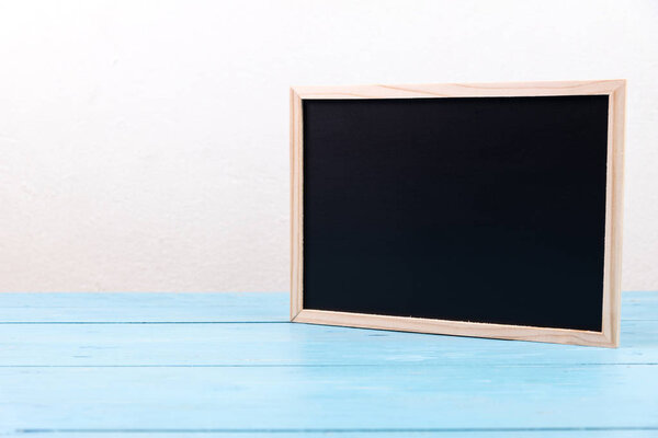 small wooden black board on blue table