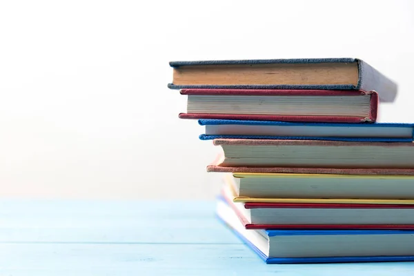 Book stack on blue wooden table — Stock Photo, Image