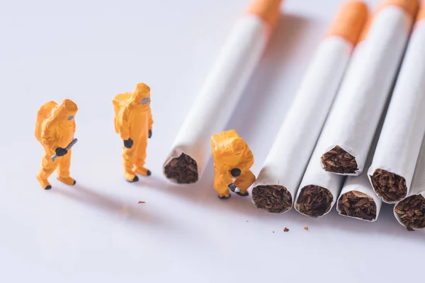 Miniature technician checking contaminants in cigarette — Stock Photo, Image