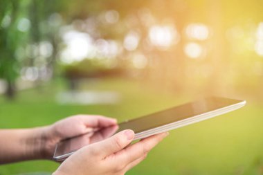 Tablet kullanan kadın oturma whilte sakin ol yeşil park