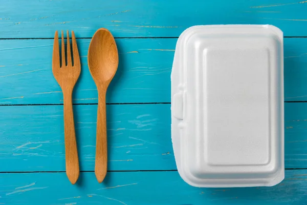 Caja de alimentos blancos con cuchara sobre mesa azul — Foto de Stock