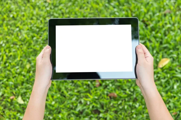 Frau benutzt Tablet, während sie im grünen Park sitzt — Stockfoto