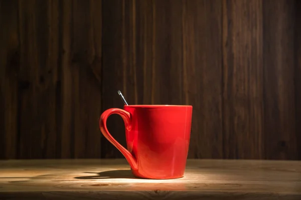 Rode koffiekopje op houten tafel achtergrond — Stockfoto