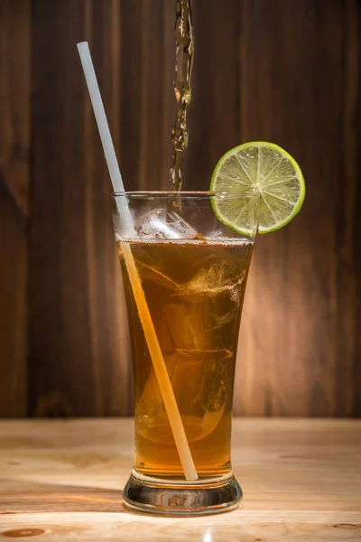 Стакан чая со льдом на деревянном столе — стоковое фото