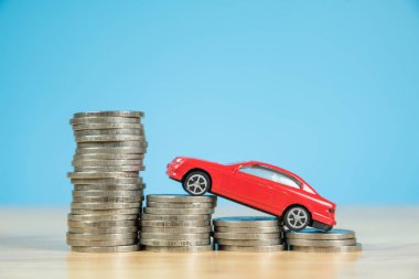 Kırmızı minyatür araba modeli sikke yığını üzerinde
